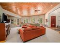 Spacious living room with a wood ceiling, large windows, and comfortable sectional sofa at 30174 Glen Eyrie Dr, Evergreen, CO 80439