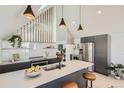 Open kitchen with island seating, pendant lighting, stainless steel appliances, and white subway tile backsplash at 1101 S Dahlia St, Denver, CO 80246