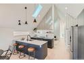 Bright kitchen featuring a skylight, eat-in island, stainless steel refrigerator and modern finishes at 1101 S Dahlia St, Denver, CO 80246