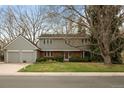 Classic two-story home featuring a well-kept lawn, mature trees, and a charming facade at 3821 S Magnolia Way, Denver, CO 80237