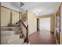 Entryway features a staircase, brick flooring, and patterned wallpaper at 3821 S Magnolia Way, Denver, CO 80237