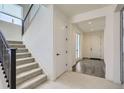 Bright entryway featuring a staircase with dark railing and a view into the adjacent rooms at 18049 E 106Th Ave, Commerce City, CO 80022