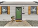 Inviting front entrance with a green door, modern hardware, and stylish shutters at 1120 Xenia St, Denver, CO 80220