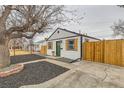Quaint home with modern landscaping and a new fence, featuring a green door and modern touches at 1120 Xenia St, Denver, CO 80220