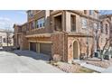 This townhouse has a brick and stucco exterior, a private balcony, and a two-car garage at 9374 Loggia St # D, Highlands Ranch, CO 80126