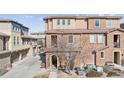 Charming exterior view of the townhouse showcasing the brick and stucco design and inviting front entrance at 9374 Loggia St # D, Highlands Ranch, CO 80126
