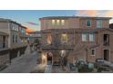Exterior view of a townhouse at dusk with a brick facade, showing the building's architecture at 9374 Loggia St # D, Highlands Ranch, CO 80126