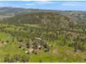 Scenic aerial shot of the property featuring rolling hills and lush greenery at 3800 Lakota Rd, Indian Hills, CO 80454