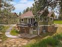 Charming home exterior with a private deck and beautiful stone foundation at 3800 Lakota Rd, Indian Hills, CO 80454