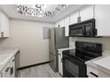 Bright kitchen with stainless steel appliances, white cabinetry, gray counters, and modern lighting at 1960 S Xanadu Way # 208, Aurora, CO 80014