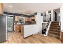 Modern kitchen with wooden cabinets, stainless steel appliances, and open floorplan with staircase access at 4917 S Xenophon Way, Morrison, CO 80465