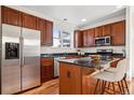 Well-equipped kitchen featuring stainless steel appliances, dark cabinets and a central island with bar seating at 12997 Wyandot Way, Westminster, CO 80234