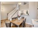 Dining room with wooden table and seating for six, open to kitchen and staircase at 3912 S Carson St # 204, Aurora, CO 80014