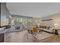 Open living room with hardwood floors, neutral tones, and a balcony view at 955 Eudora St # 203E, Denver, CO 80220