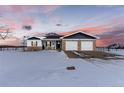 Charming ranch home with a two-car garage and beautiful landscaping at sunset at 11499 County Road 40 1/2 Rd, Platteville, CO 80651