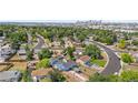 Aerial view of a blue single-story home and neighborhood with Denver skyline in background at 935 S Pecos Way, Denver, CO 80223