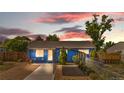 Charming blue single-story home with a well-maintained front yard and unique covered parking at 935 S Pecos Way, Denver, CO 80223