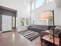 Bright living room with tall windows, hardwood floors, and a gray sofa at 9816 S Holland St, Littleton, CO 80127