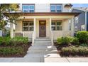 Inviting front porch with classic columns, decorative wreath, and manicured landscaping at 10822 E 28Th Pl, Denver, CO 80238