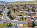Expansive aerial shot showcasing a peaceful neighborhood with lush greenery and mountain views at 13223 W Utah Cir, Lakewood, CO 80228