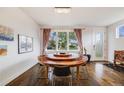 Bright dining room with unique round table, modern chandelier, and hardwood floors at 4390 Osage St, Denver, CO 80211