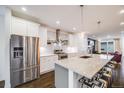 Modern kitchen with stainless steel appliances, white cabinets, and large island with seating at 4390 Osage St, Denver, CO 80211