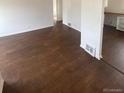 Open-concept living room with hardwood floors leading to dining area at 2017 Ironton St, Aurora, CO 80010