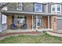 Charming front porch with brick accents, cozy seating, and inviting entrance at 9786 Malachite Ct, Parker, CO 80134