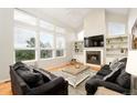 Bright living room with a fireplace, large windows, vaulted ceilings, and comfortable seating at 9786 Malachite Ct, Parker, CO 80134