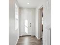 Bright foyer with wood-look flooring, a large window and a white front door at 1401 Bloom St, Brighton, CO 80601