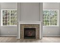 Living room fireplace with decorative mantle and tile surround, flanked by two large windows at 2732 Flint Ct, Superior, CO 80027