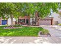Beautiful two-story brick home with mature landscaping, lush green lawn, and a two-car garage at 2732 Flint Ct, Superior, CO 80027