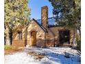 Charming brick home with wood front door and snowy landscaping at 636 York St, Denver, CO 80206