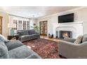 Cozy living room with hardwood floors, sofas, and a fireplace with a TV mounted above at 636 York St, Denver, CO 80206