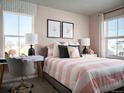 Charming bedroom with pink accents, a desk area, and natural light from two windows at 249 E 4Th St, Berthoud, CO 80513