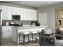 Modern kitchen with white cabinets, an island with seating, and stainless steel appliances at 249 E 4Th St, Berthoud, CO 80513