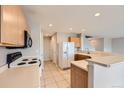 Functional kitchen with neutral countertops and tile flooring next to staircase and open-concept design at 5653 Raleigh Cir, Castle Rock, CO 80104