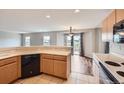 Open kitchen with breakfast bar overlooking the living area and sliding door to the exterior at 5653 Raleigh Cir, Castle Rock, CO 80104