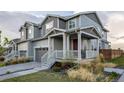 Attractive townhome with a welcoming front porch, gray siding, and well-maintained lawn at 9590 Sedalia St, Commerce City, CO 80022