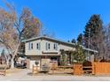 Charming home with light siding, wooden fence and shutters creates welcoming outdoor ambiance at 8721 E Cornell Dr, Denver, CO 80231