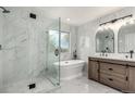 Bright bathroom features a glass shower, soaking tub and double sink vanity with marble tile surround at 5977 S Rock Creek Dr, Castle Rock, CO 80109