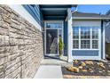 Close up of front door with stylish stone accent wall, and well-manicured landscaping with rocks at 5977 S Rock Creek Dr, Castle Rock, CO 80109