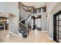 Grand foyer featuring a winding staircase, high ceilings, and light wood floors at 10774 Chadsworth Ln, Highlands Ranch, CO 80126