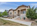 Attractive one-story home with stone accents and a covered porch, complimented by mature landscaping at 13275 E Caley Pl, Centennial, CO 80111
