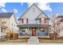 Charming two-story home featuring a welcoming front porch and red shutters against a blue exterior on a sunny day at 3269 Uinta St, Denver, CO 80238