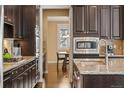 A kitchen featuring granite counters, and dark wood cabinets with stainless steel appliances at 3269 Uinta St, Denver, CO 80238