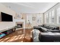 Cozy living room featuring hardwood floors, a fireplace, and a comfortable leather sofa at 3269 Uinta St, Denver, CO 80238