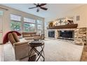 Living room featuring a fireplace with stone accents and large windows for natural light at 9724 Crowsley Ct, Parker, CO 80134