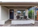 Inviting front porch with two wicker chairs and a small table at 5550 E Thrill Pl, Denver, CO 80207