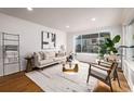 Bright and airy living room with hardwood floors and modern furniture at 5550 E Thrill Pl, Denver, CO 80207